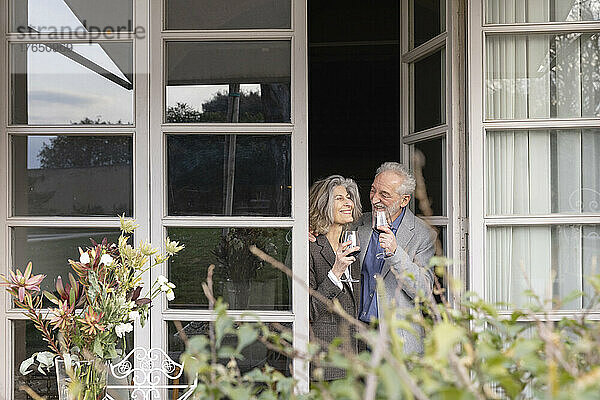 Glückliches älteres Paar  das vor der Tür steht