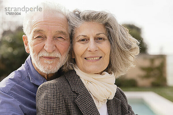 Lächelndes älteres Paar an einem sonnigen Tag