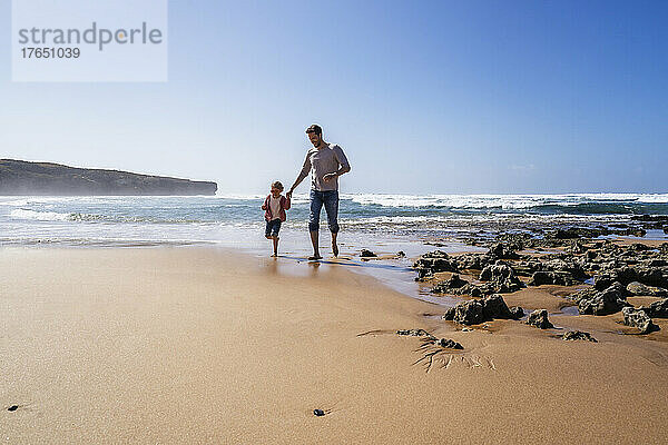 Glücklicher Vater und Tochter genießen den Strand an einem sonnigen Tag