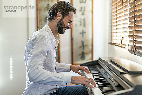 Mann spielt zu Hause Klavier