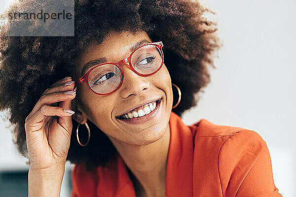 Lächelnde Geschäftsfrau mit Afro-Frisur und Brille