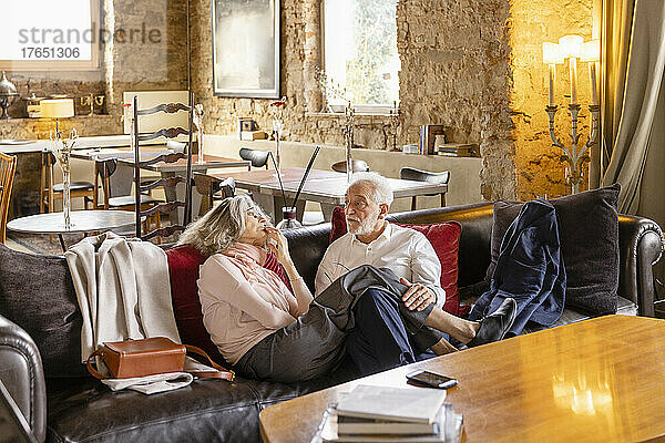 Älteres Paar unterhält sich auf dem Sofa im Boutique-Hotel
