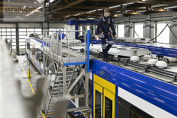 Ingenieur läuft auf dem Dach der Einschienenbahn in der Fabrik