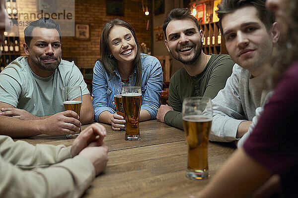 Gruppe von Freunden  die Bier trinken und sich in einer Kneipe unterhalten