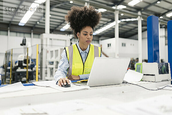 Ingenieur benutzt Laptop am Schreibtisch in der Fabrik