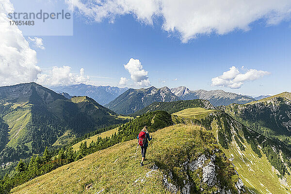 Frau trägt Rucksack beim Wandern an einem sonnigen Tag