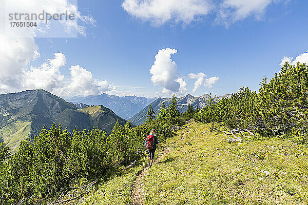 Wanderer mit Rucksack beim Wandern an einem sonnigen Tag