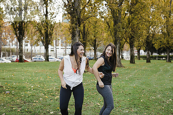 Glückliche Schwestern  die Spaß im öffentlichen Park haben