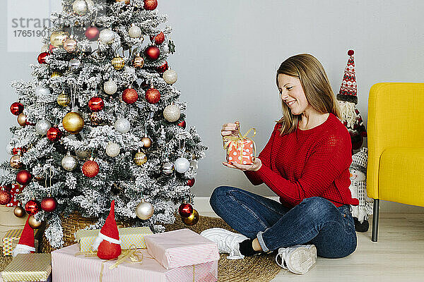 Glückliche Frau  die zu Hause Weihnachtsgeschenke öffnet
