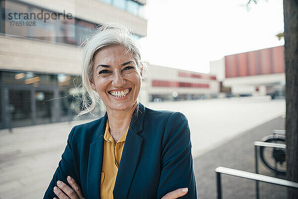 Glückliche Geschäftsfrau mit grauen Haaren im Büropark