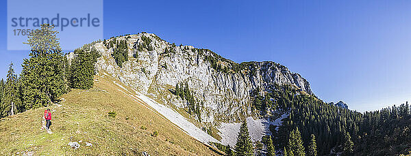 Panoramablick auf eine Wanderin  die die Landschaft der Bayerischen Voralpen bewundert