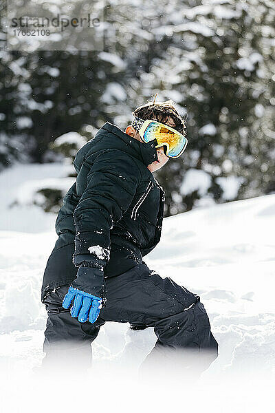Junge mit Skibrille läuft im Schnee