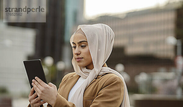 Junge Geschäftsfrau im Hijab mit Tablet-PC
