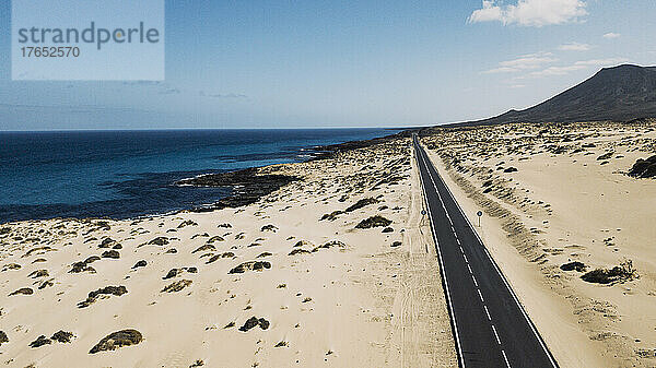 Spanien  Fuerteventura  Luftaufnahme einer Autobahn  die sich durch die sandige Landschaft des Naturparks Corralejo erstreckt