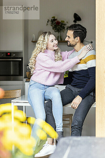 Romantic couple sitting on table at home