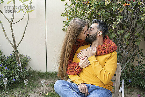 Zärtliches Liebespaar küsst sich im Hinterhofgarten