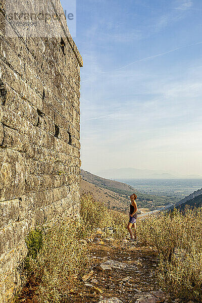 Frau blickt auf die antike Mauer  Orraon  Arta  Griechenland