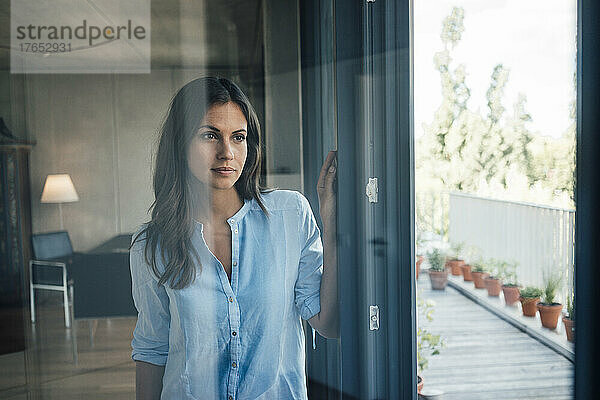 Beautiful woman seen through glass at home
