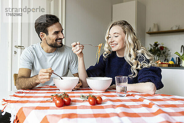 Paar isst gemeinsam am Esstisch zu Hause