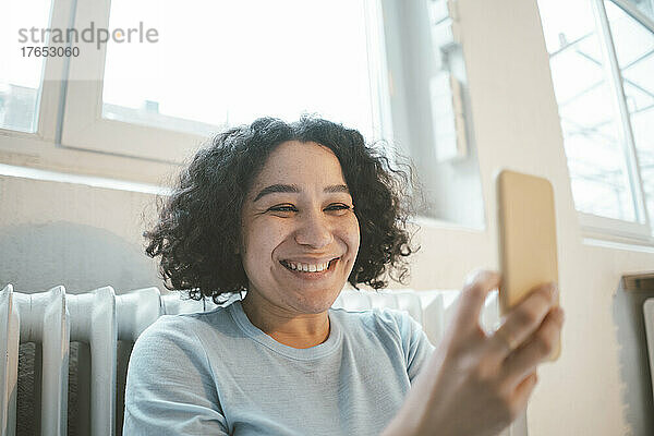 Glückliche Frau  die zu Hause ein Selfie mit dem Smartphone macht