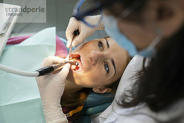 Zahnarzt untersucht Patientenzähne mit zahnärztlicher Ausrüstung in einer medizinischen Klinik