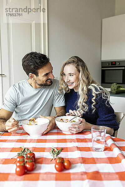 Romantisches Paar isst zu Hause am Esstisch
