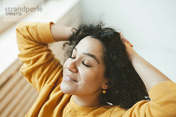 Beautiful woman with eyes closed relaxing at home