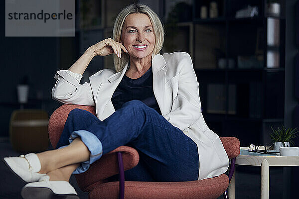 Smiling businesswoman sitting on chair at home office