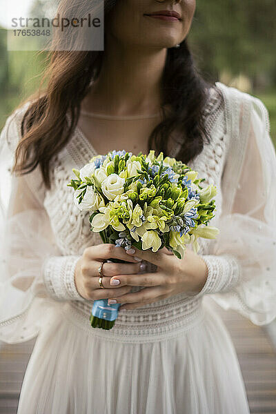 Lächelnde Braut mit Blumenstrauß