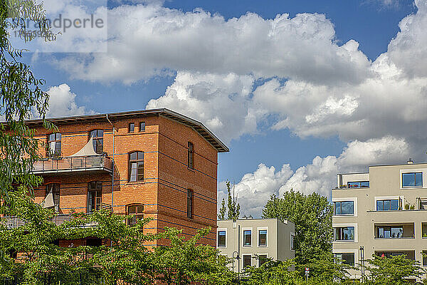 Deutschland  Berlin  Wolken über modernen Mehrfamilienhäusern im Neubaugebiet