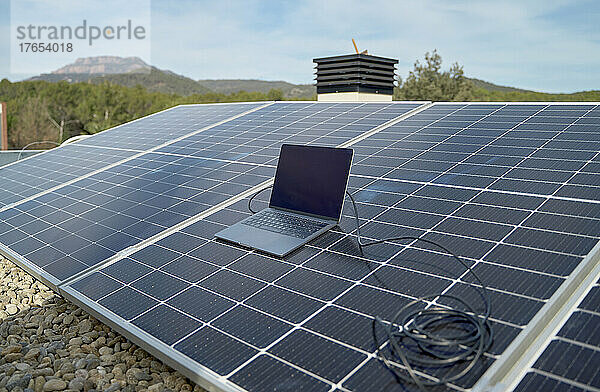 Laptop mit Kabel an Solarpaneele angeschlossen