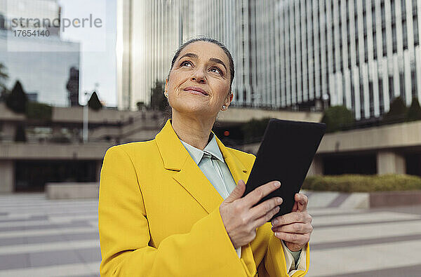 Nachdenkliche Geschäftsfrau mit Tablet-PC im Büropark