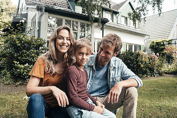 Lächelnde blonde Frau mit Mann und Sohn im Hinterhof