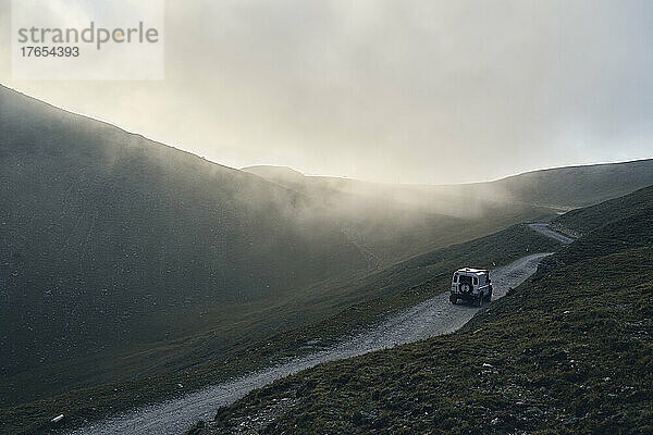 Offroad-Fahrzeug auf der Straße durch Berge