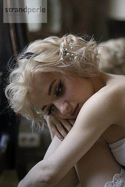 Nachdenkliche junge Frau mit blonden Haaren