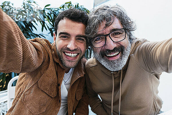 Glücklicher Vater und Sohn machen gemeinsam ein Selfie im Hinterhof