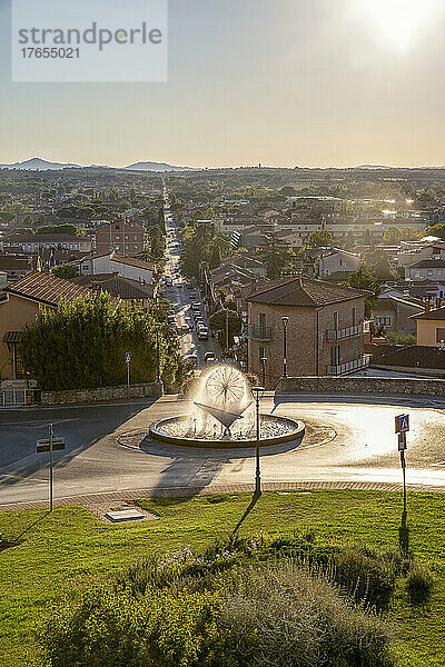 Fountain and town view from high on sunny day  Castiglione del Lago  Umbria  Italy