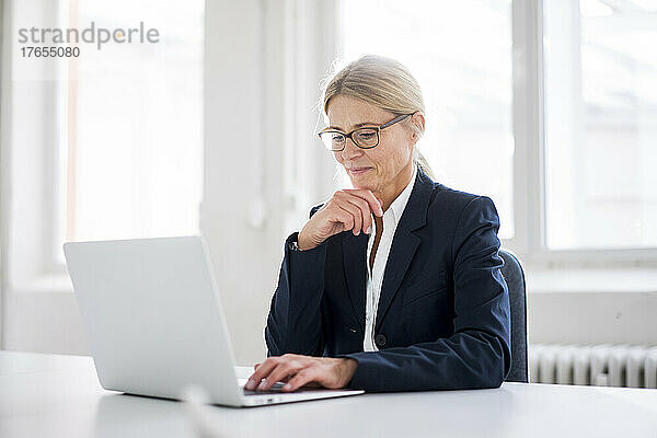 Geschäftsfrau arbeitet am Arbeitsplatz am Laptop