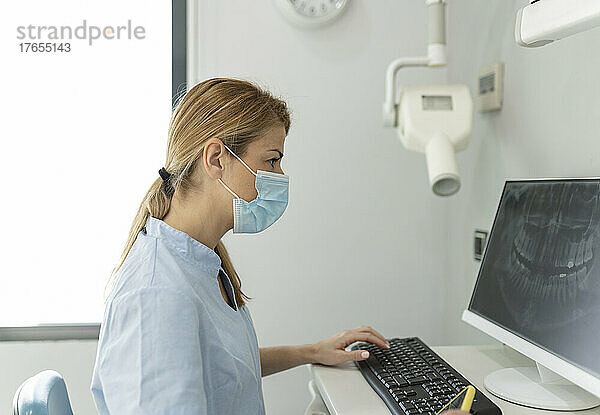 Zahnarzt untersucht Röntgenbild am Computer in der Zahnklinik