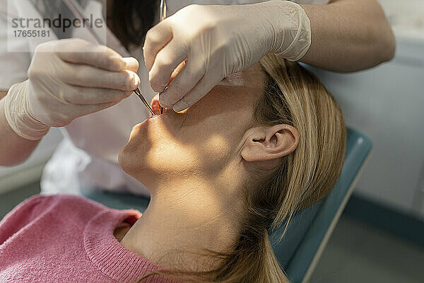 Zahnarzt untersucht Zähne des Patienten in der Zahnklinik