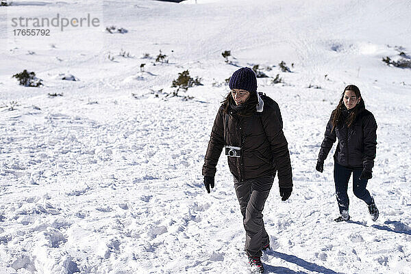 Zwei Frauen wandern auf einem schneebedeckten Berg