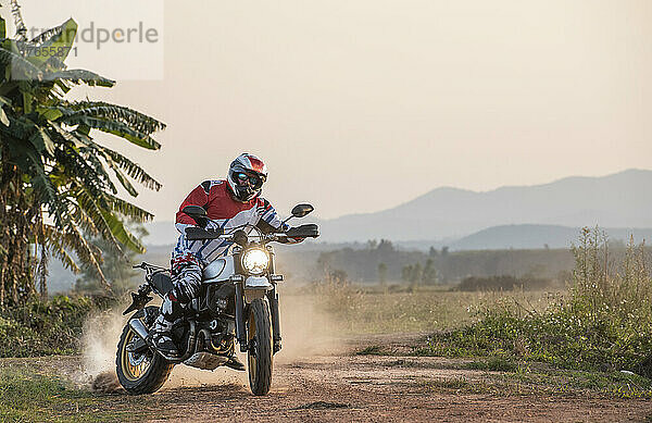 Mann fährt mit seinem Scrambler-Motorrad in Nordthailand