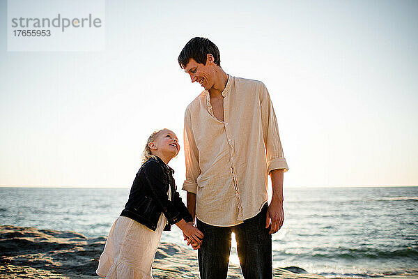 Vater und Tochter halten sich am Strand von San Diego an den Händen