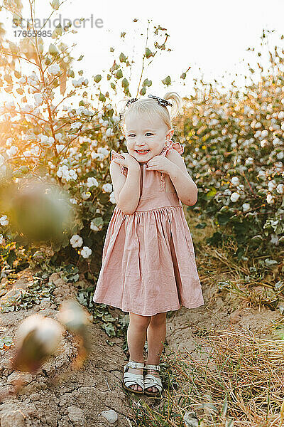 kleines Mädchen lächelt vor Blumen