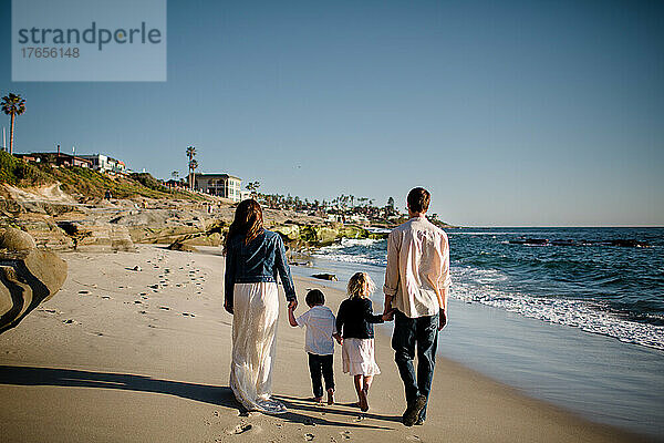 Vierköpfige Familie spaziert am Strand von San Diego