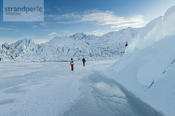 Zwei Menschen gehen auf dem Eisfeld am Matanuska-Gletscher in Alaska