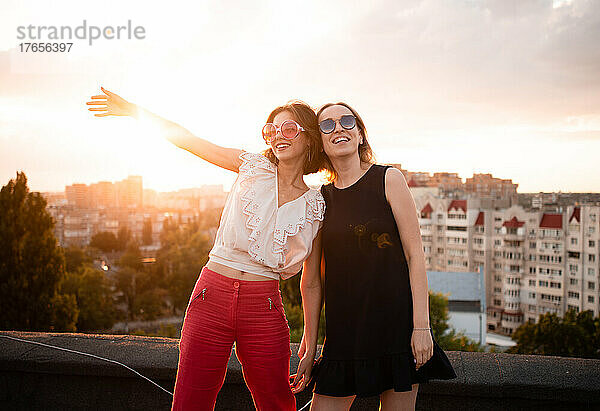 Zwei Freunde auf dem Dach bei Sonnenuntergang