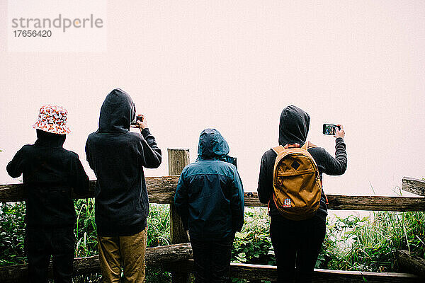 Gruppen stehen am Cloudy Overlook und machen Fotos mit ihren Handys