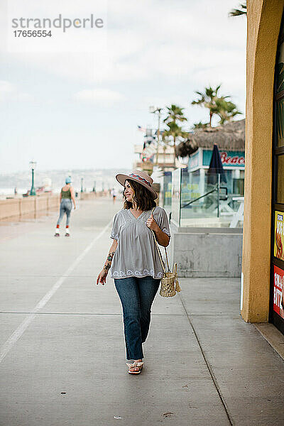 Multirassische Frau  die auf der Promenade in San Diego spaziert