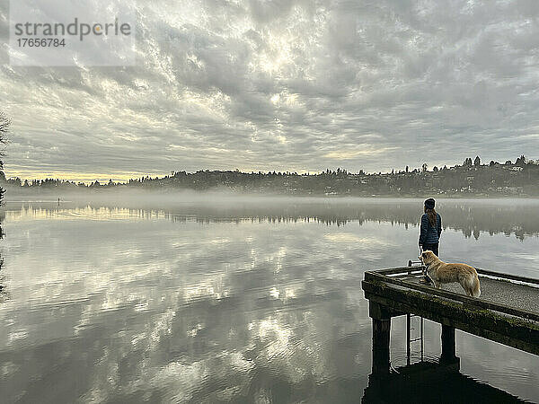 Weibchen und ihr Hund stehen auf dem Dock im Seward Park